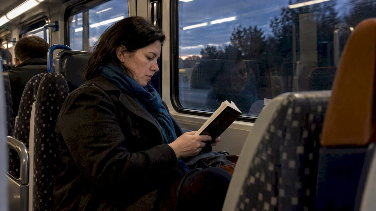 Commuter reading a thriller on a train